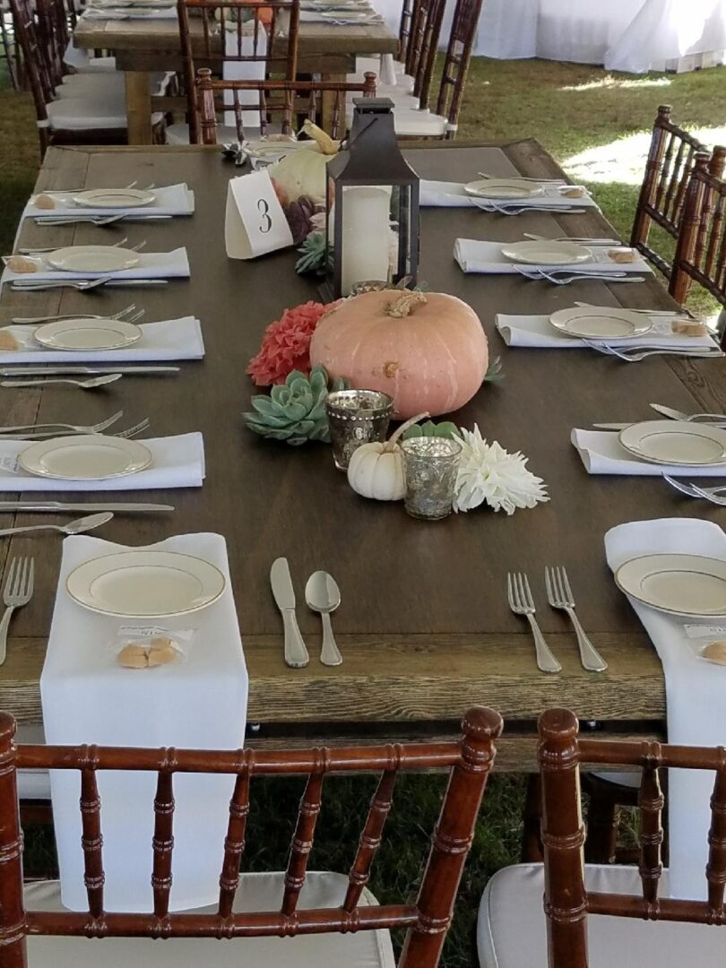 A table set with plates, silverware and pumpkins.